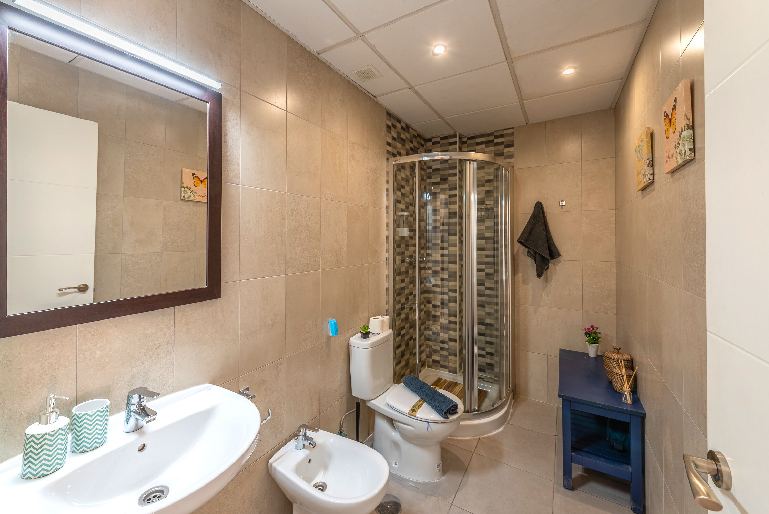 Un baño con lavamanos, bidé, inodoro y ducha.