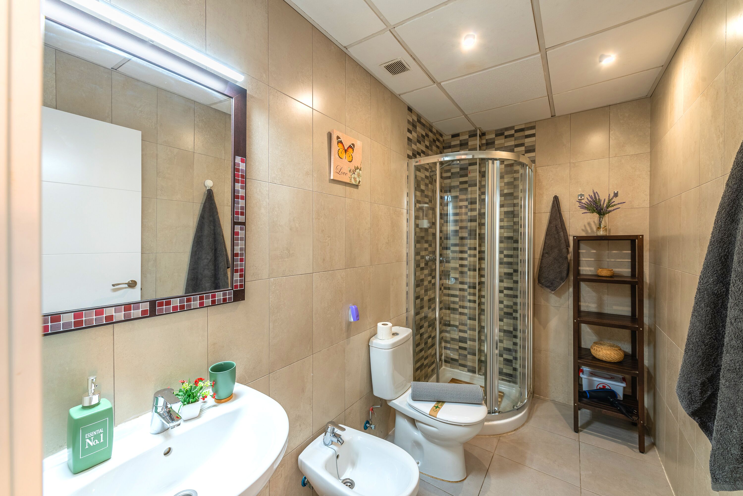 A modern bathroom with a sink, toilet, and shower.