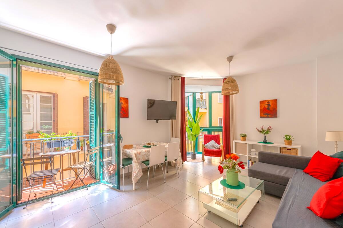 Sala de estar luminosa com sofá, mesa de centro e espaço para refeições.