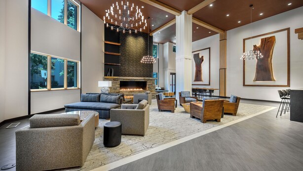 Eine geräumige Lobby mit Kamin, modernen Sitzgelegenheiten und großen Fenstern.