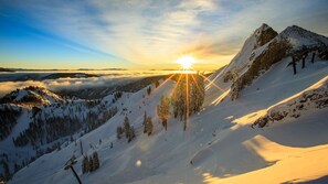 A snow-covered mountain landscape with a ski lift and a clear sky.