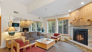 A modern living room with a fireplace, a sofa, a red chair, and a coffee table. - 521 | Roomy 2BD/2BA - Kitchen, W/D, Pool + Spas (Olympic Valley)