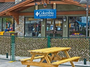 Tienda de ropa deportiva llamada Columbia Sportswear Company con una mesa de picnic de madera al frente.