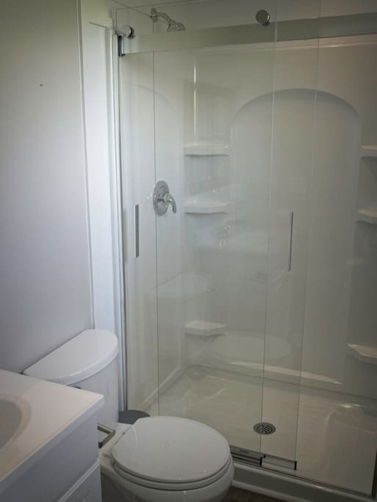 Ein Badezimmer mit einer Duschkabine, einer Toilette und einem Waschbecken.