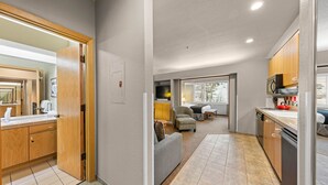 Hotellihuone, jossa on pieni keittiö, sänky, oleskelualue ja kylpyhuone.