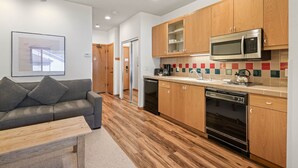 Una cocina moderna con armarios de madera, microondas, lavavajillas y cafetera.