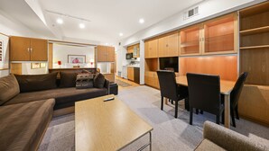 Una sala de estar moderna con un sofá, una mesa de centro y un comedor con sillas y una mesa.