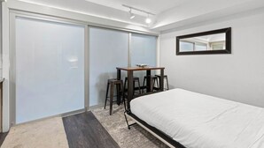 A bedroom with a bed, a desk with chairs, a mirror, and a sliding door. - 227 | Studio Retreat - Hike & Golf Your Days Away (Olympic Valley)