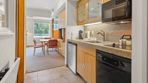 A modern kitchen with wooden cabinets, a stainless steel microwave, and a dishwasher.