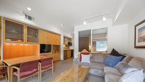 A compact living space with a dining area, kitchen, and seating area.