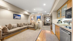 Una sala de estar acogedora con un sofá modular, un comedor y una kitchenette.