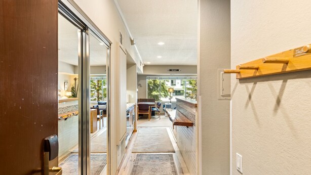 A hallway leading to a dining area with a view of the outdoors.