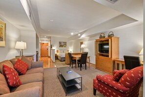 A hotel room with a sofa, a coffee table, a TV cabinet, and a dining area with a table and chairs. - 203 | Open Studio - Soak & Chill w/Pool Views (Olympic Valley)