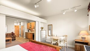 Un dormitorio moderno con cama, escritorio y comedor.