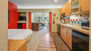 Un appartement moderne et compact comprenant une kitchenette, un coin repas et un salon.
