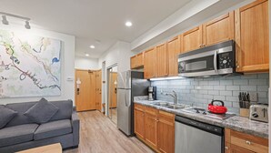 A modern kitchen with wooden cabinets, a stainless steel refrigerator, a microwave, and a red kettle. - 149 | Modern Studio w/ A/C, Wi-Fi, Views & Pool (Olympic Valley)