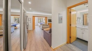 A spacious living area with a sofa, a dining table, and a kitchen with cabinets and a countertop. - 149 | Modern Studio w/ A/C, Wi-Fi, Views & Pool (Olympic Valley)