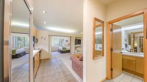 A hotel room with a bed, a desk, a chair, a TV, and a bathroom with a mirror and sink. - 148 | Affordable Studio - Mtn Escape w/ Pool & Spa (Olympic Valley)