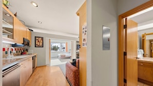 A modern kitchen with wooden cabinets, a microwave, and a large window. - 147 | Studio Escape - Tubs, Trails & Tranquility (Olympic Valley)
