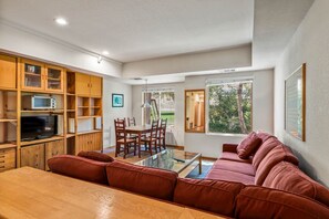 Relax in this stylish living room with a dining table, comfortable sofa, and flat-screen TV.
