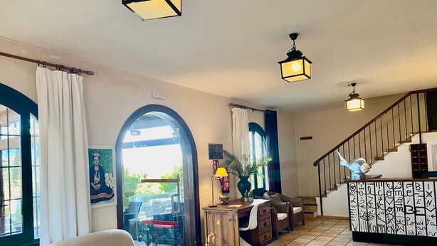 A spacious living area with a sofa, a desk, and a staircase. - Hôtel rural castillo de biar (Biar)