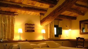 A cozy room with a bed, two bedside lamps, a wooden headboard, a mirror, and a window with curtains. - Hôtel rural castillo de biar (Biar)