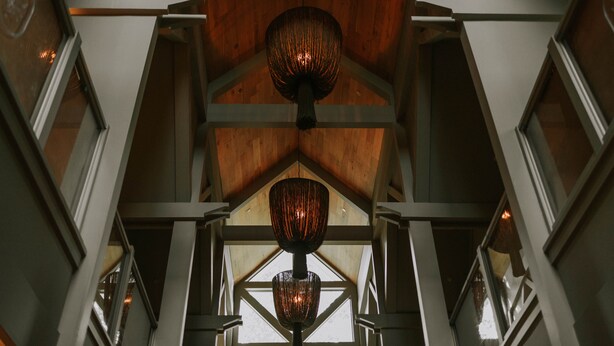 A high-ceilinged interior with a wooden ceiling and a central hanging light fixture. - The Springs Hotel (Ocean Springs)