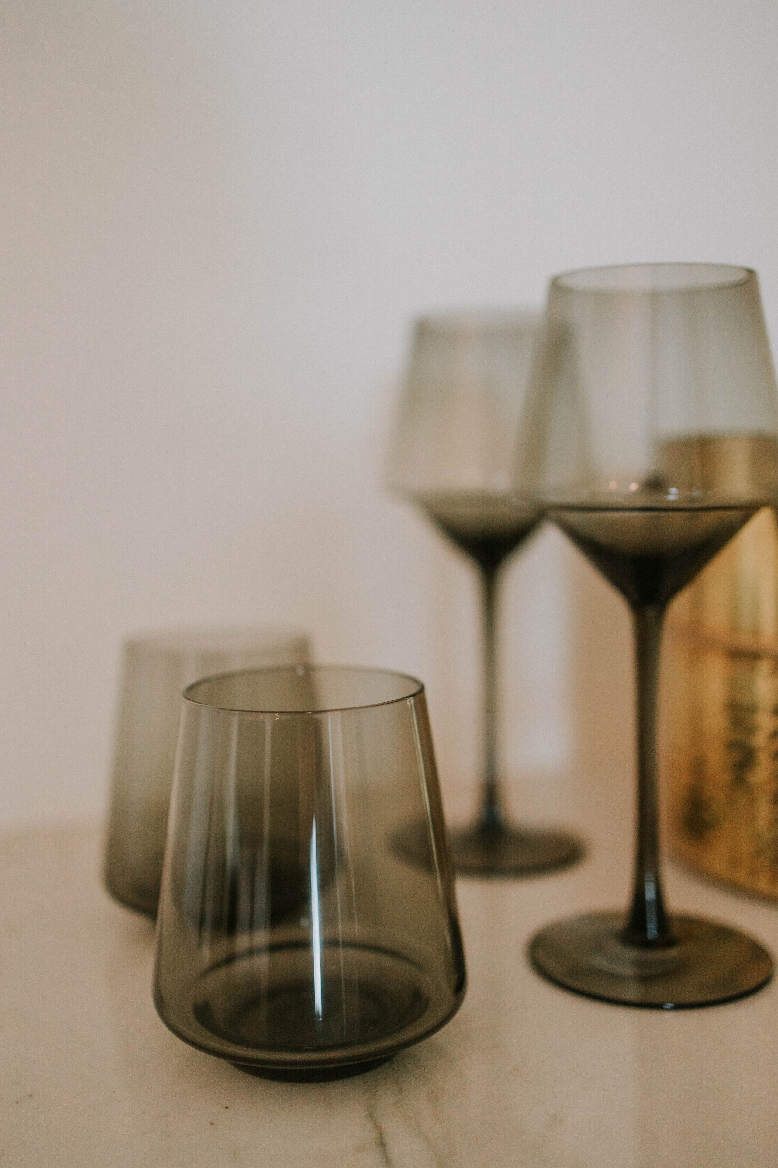 Three wine glasses on a marble surface.