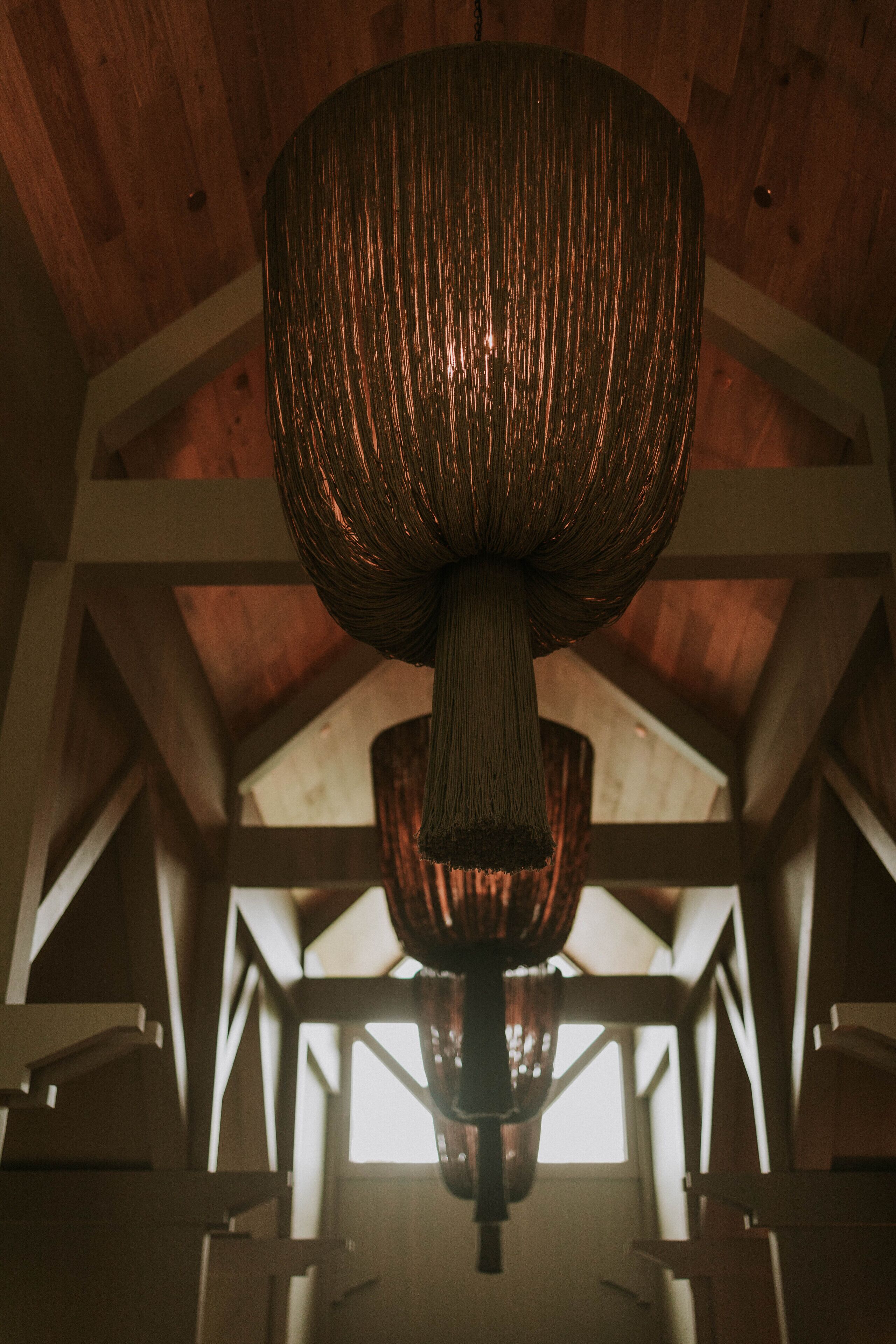 Un plafond avec un luminaire suspendu au centre, dans un intérieur en bois.
