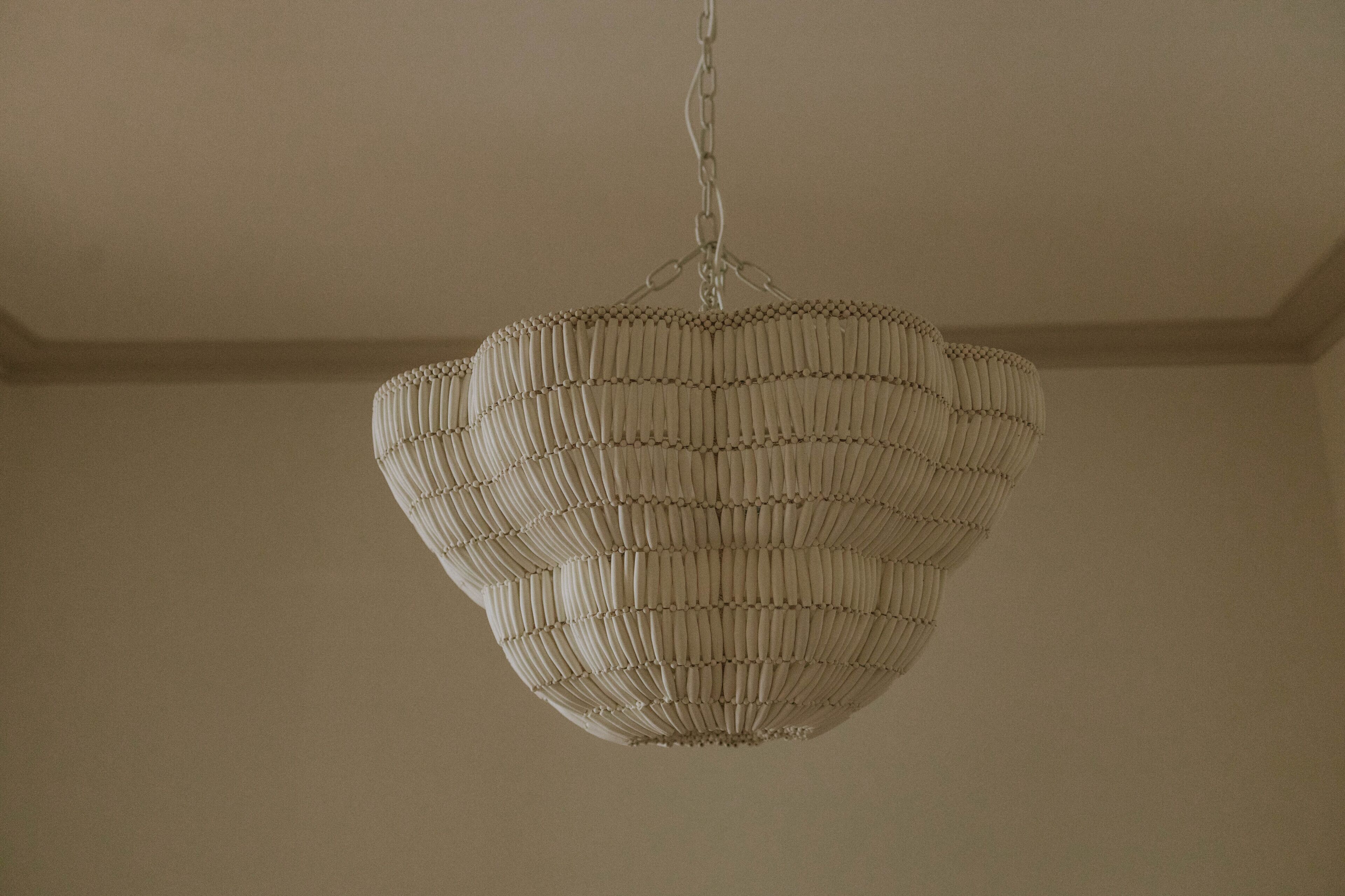 A spherical chandelier with a ribbed design hanging from a chain.