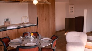 Un comedor con una mesa redonda, sillas y una lámpara colgante.
