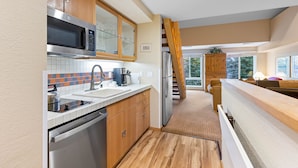 A modern kitchen with stainless steel appliances, wooden cabinets, and a tiled backsplash. - 334 | Mtn Loft Escape w/ A/C - Fridge, Tubs & Gym (Olympic Valley)