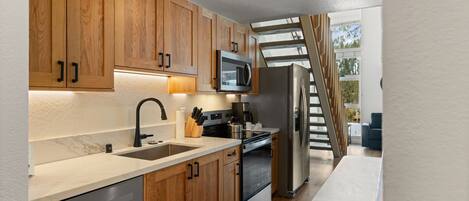 Your fully equipped kitchen features warm wood cabinetry, granite counters, and stainless steel appliances for memorable meal preparation.