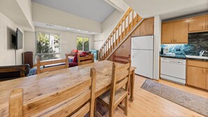 Une cuisine spacieuse avec des meubles de rangement en bois, un réfrigérateur blanc et un four encastré.