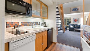 A modern kitchen with a dishwasher, microwave, and a colorful backsplash. - 314 | Loft Escape - King Bed, Views, Hike & Bike (Olympic Valley)