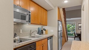 Une cuisine moderne avec des meubles en bois, des appareils en acier inoxydable et un plan de travail en granit.