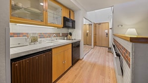 A modern kitchen with wooden cabinets, a microwave, and a dishwasher. - 305 | Pool View A/C Loft!  - Tubs, Sauna & Fun (Olympic Valley)