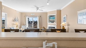 A modern kitchen with a central island, a ceiling fan, and a view of the city through large windows.
