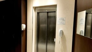 A modern elevator with a metallic finish, a wall-mounted phone, and a sign indicating it is a lift. - Apartment in Palermo Hollywood, Buenos Aires, Argentina (Buenos Aires)