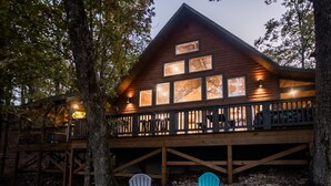 Eine Holzhütte mit einer Terrasse und mehreren Fenstern.