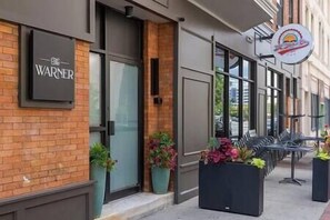 A storefront with a 'WARNER' sign, large windows, and outdoor seating.