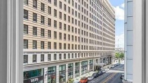 A multi-story hotel with a uniform facade, large windows, and a ground-level retail space. - Modern Downtown 1BR | Free Garage Parking + Workspace (Wilmington)