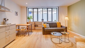 Un salon moderne avec un canapé, une table basse et un coin repas.