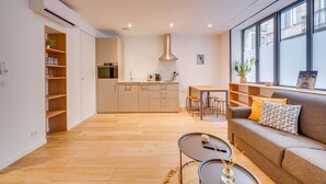 Un salon moderne avec un canapé, une table basse et un coin repas.