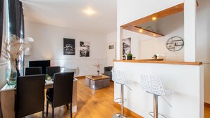 A modern kitchen with a wooden countertop, a built-in oven, and a hanging light fixture.