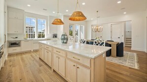 A spacious kitchen with white cabinets, a marble island, and pendant lighting. - "62 Blue View" Lakefront Private Pool Short Walk to the Beach (Santa Rosa Beach)