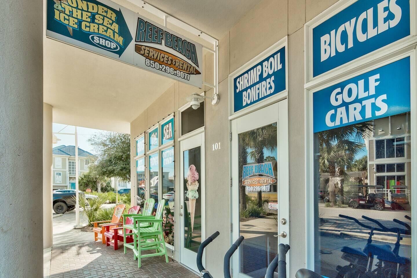 A storefront with signs for 'Reef Beach Services & Rental', 'Shrimp Boil Bonfires', 'Bicycles', and 'Golf Carts'.