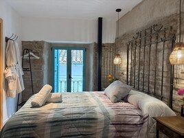 Una camera da letto con un letto, una lampada a sospensione, una porta con vista e un porta asciugamani.