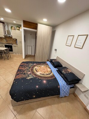 A bedroom with a bed, a bedside table, and a wall with two framed inspirational quotes.