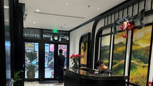 A reception area with a black counter, a large window with a scenic view, and a potted plant. - Palago Boutique Hotel (Hanoi)